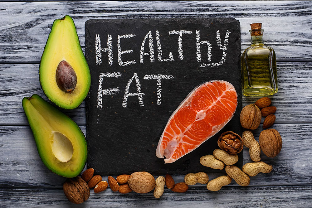 Natural sources of saturated fat like butter, eggs, and coconut oil arranged on a kitchen counter