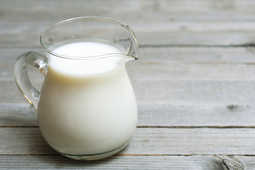 Glass of raw milk on a table representing its nutritional benefits and safety considerations