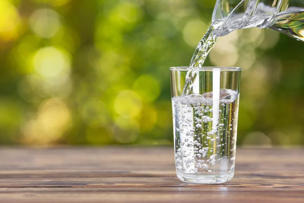 Glass of tap water with potential contaminants and health risks